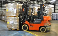 Forklift truck in warehouse. Pallet racking protectors help prevent forklifts damage to racking