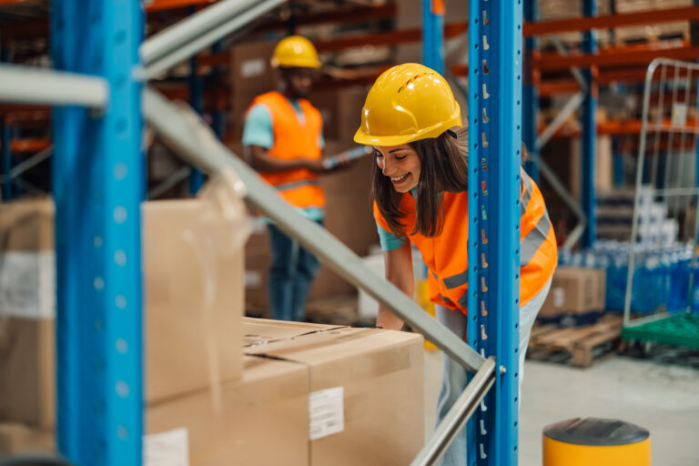 A female warehouse employee examines storage space with great attention to detail, showcasing precision and organization in managing warehouse inventory, underscoring efficiency.